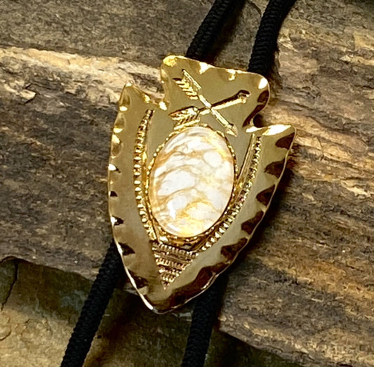 Lightweight golden arrowhead bolo with gold and white stone